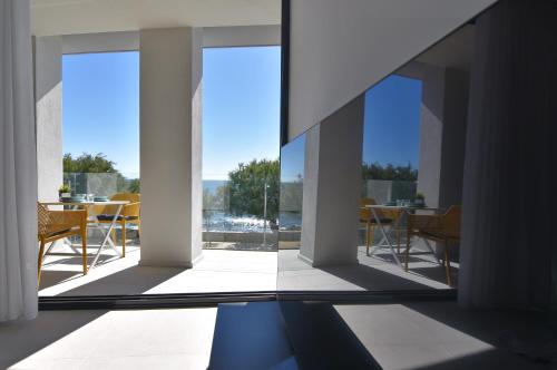 Habitación con ventanas grandes y mesa con sillas. en LLUISALBERT, en L'Escala