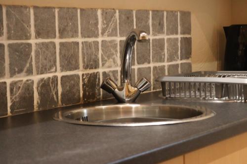 a kitchen sink with a faucet on a counter at Cosy Ardrossan Apartment in Ardrossan