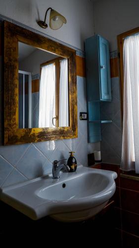a bathroom with a white sink and a mirror at Villa Assunta in Tertenìa