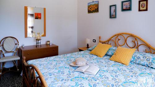 a bedroom with a bed with a book and a hat on it at Villa Assunta in Tertenìa