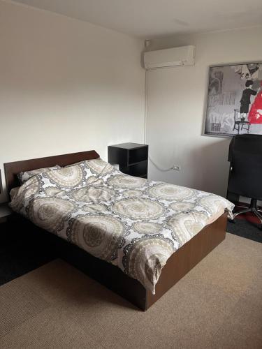 a bedroom with a bed with a blanket on it at Vila cu trandafiri - Cozy Apartments Studio cu pat matrimonial in Bragadiru