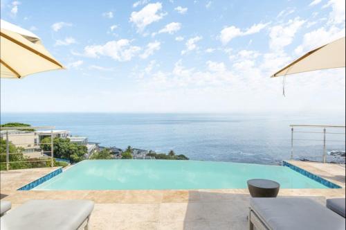 a swimming pool with a view of the ocean at CapeStays - Villa Infinity in Cape Town
