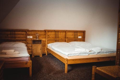 two beds in a bedroom with wooden cabinets at Penzion u Hajneho Bedricha in Harrachov