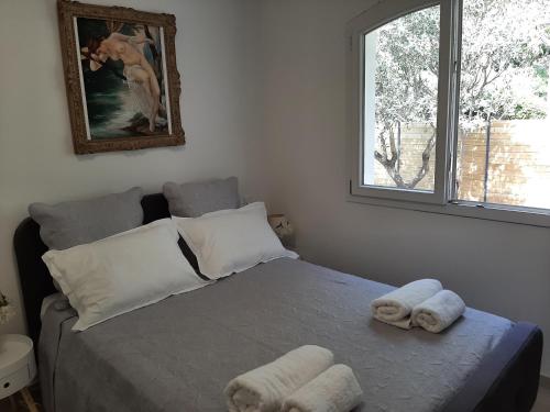 a bedroom with a bed with towels on it at VILLA RASOA chambre LIBELLULE in Cap d'Agde