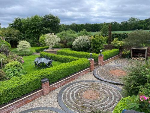 un jardín con una mesa en el medio. en Beautiful 3 Bedroom Cottage - Picturesque Retreat, en Lichfield
