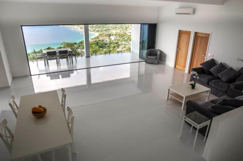 Paradise Heights Luxury Apartments & Villa في بو فالون: غرفة معيشة مع أريكة وطاولة وكراسي