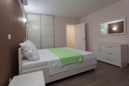 a small bedroom with a bed and a mirror at Buna Spring Apartments in Mostar