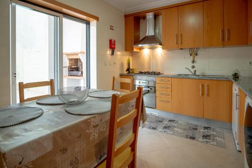 a kitchen with a table and a large window at Sea House in Nazaré