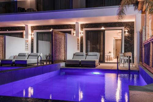 a swimming pool with lounge chairs next to a house at Vanik Suites in Faliraki