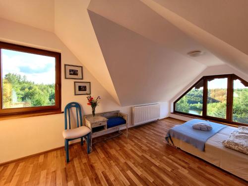 - une chambre avec un lit et une grande fenêtre dans l'établissement Kaszubski Horyzont, à Pierszczewo