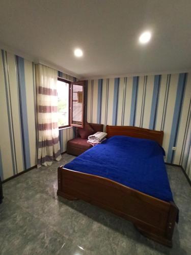 a bedroom with a blue bed and a red couch at Guest house DAVID in Borjomi