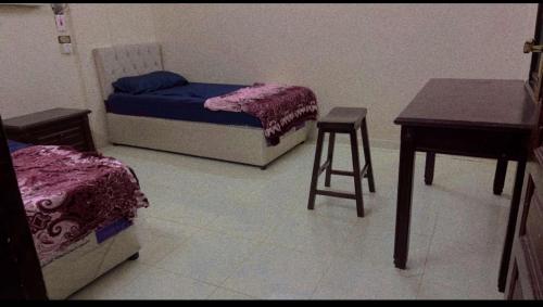 a room with two beds and a table and a stool at Hostel 35 in Medina