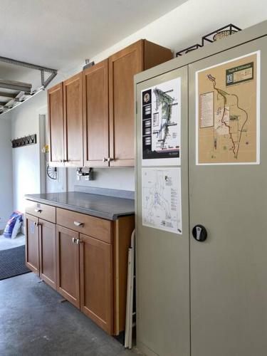 a kitchen with wooden cabinets and a refrigerator at STARLANDING, 2 Kngs/2 Twns; DT/Museums/Trails in Bentonville