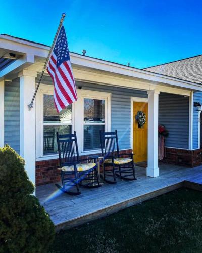 a porch with two chairs and an american flag at STARLANDING, 2 Kngs/2 Twns; DT/Museums/Trails in Bentonville