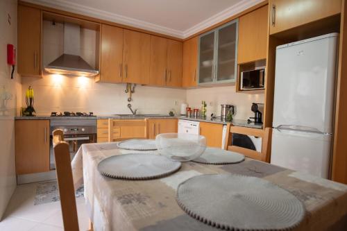 a kitchen with a table with four plates on it at Sea House in Nazaré
