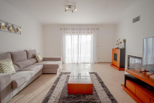 a living room with a couch and a tv at Sea House in Nazaré