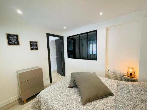 une chambre avec un lit et une télévision au mur dans l'établissement La Suquetane, à Cannes