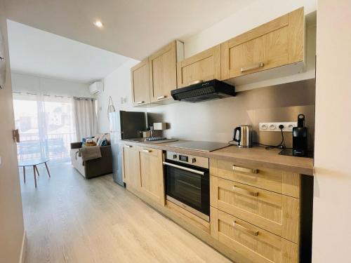 une cuisine avec des armoires en bois et un four à plaques de cuisson dans l'établissement La Suquetane, à Cannes