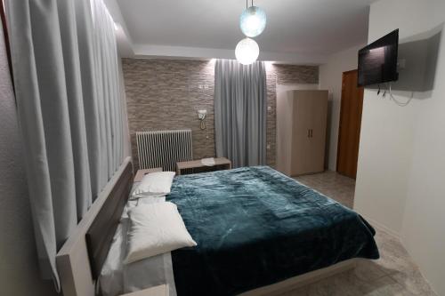 a bedroom with a large bed and a television at Guesthouse Alexandros in Nestorio