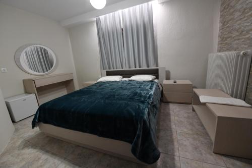 a small bedroom with a bed and a mirror at Guesthouse Alexandros in Nestorio