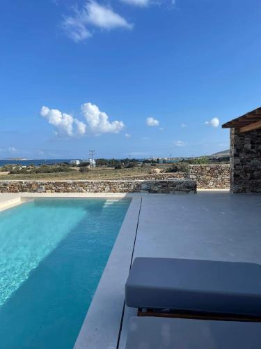 a swimming pool with a bench next to a house at Sorokos Villa Panagia beach in Andiparos
