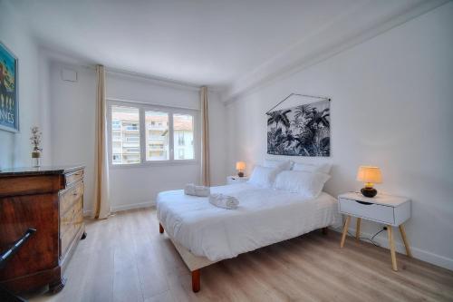 une chambre avec un lit, une commode et une fenêtre dans l'établissement IMMOGROOM - Spacieux 3 pièces - Garage - Terrasse - Climatisation, à Cannes
