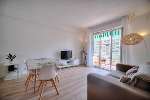 un salon avec un canapé et une table dans l'établissement IMMOGROOM - Spacieux 3 pièces - Garage - Terrasse - Climatisation, à Cannes