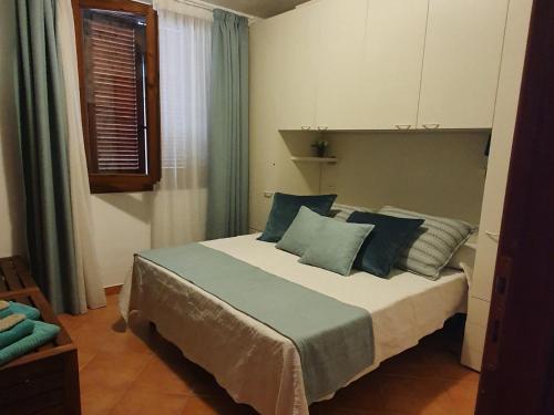 una camera da letto con un grande letto con cuscini blu di CASA BIJOUX a Olbia
