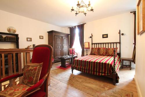 sypialnia z łóżkiem i krzesłem w obiekcie Le Presbytère, Cotentin, Val de Saire, Fermanville, proximité immédiate mer et forêt w mieście Fermanville