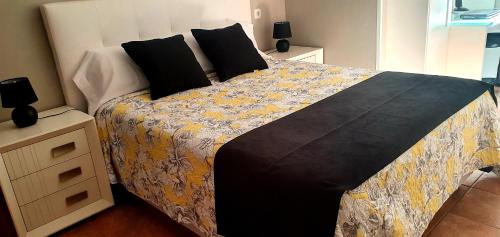 ein Schlafzimmer mit einem großen Bett mit einer schwarzen und gelben Decke in der Unterkunft Apartamento Carmen in Morro del Jable
