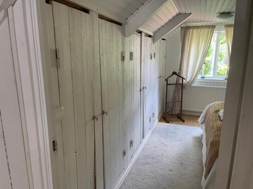 a room with white wooden walls and a window at Pia's House in Gothenburg
