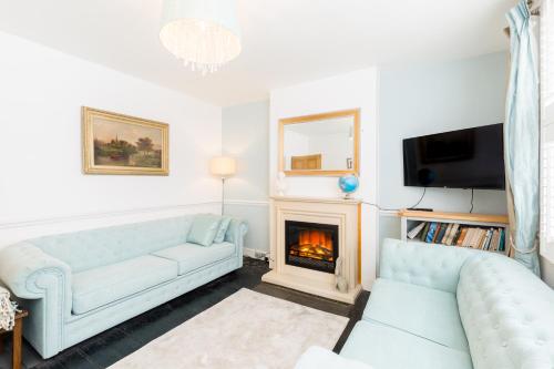 a living room with a couch and a fireplace at Shakespeare House Town Centre FREE Parking in Stratford-upon-Avon