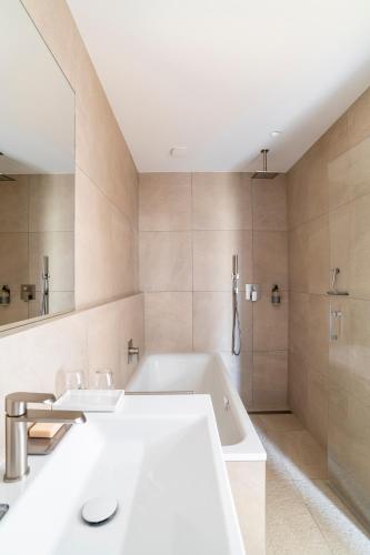 a bathroom with two sinks and a bath tub at Château Toulouse-Lautrec in Saint-André-du-Bois