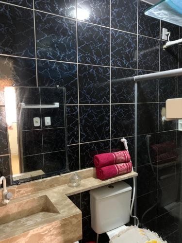 baño con una pared de azulejos negros en Casa com piscina no centro de Maragogi pertinho da praia! en Maragogi