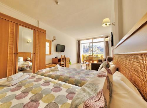 a hotel room with two beds and a window at Palm Beach View in Puerto de la Cruz
