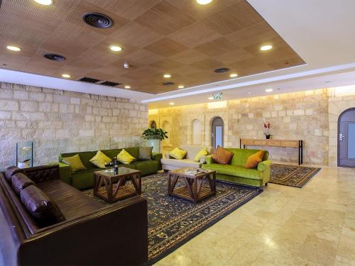 una gran sala de estar con sofás y mesas. en The Sephardic House Hotel in The Jewish Quarter, en Jerusalén