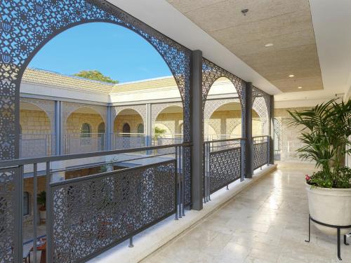 an arched hallway with blue tiles and a balcony at The Sephardic House Hotel in The Jewish Quarter in Jerusalem