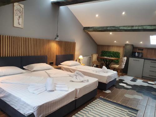 ein Schlafzimmer mit 2 Betten und eine Küche mit einem Tisch in der Unterkunft Kamelia guest rooms in Kasanlak