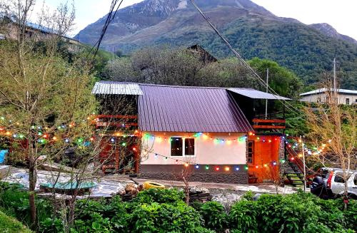 a house with christmas lights in front of a mountain at Kesane in Jut'a