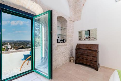 a bedroom with a window and a dresser and a view at Suite Fronte Valle in Cisternino