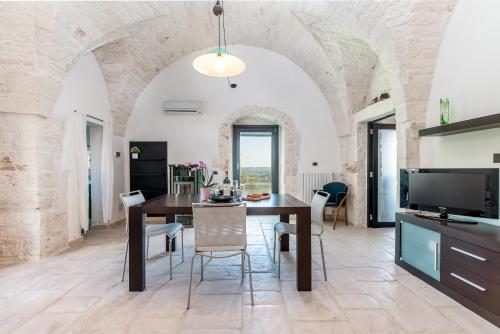 cocina y comedor con mesa y sillas en Suite Fronte Valle, en Cisternino