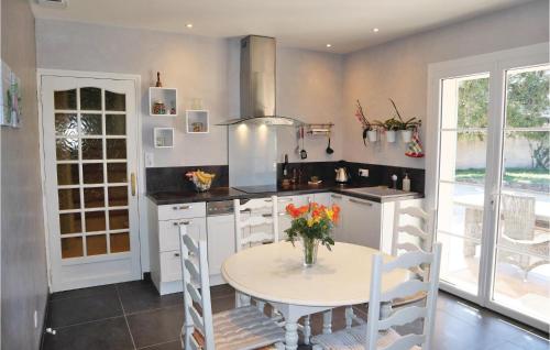 une cuisine avec une table avec un vase de fleurs dessus dans l'établissement Lovely Home In Valreas, à Valréas