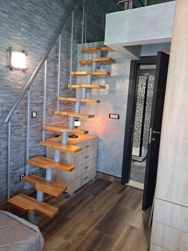 a wooden staircase in a room with a brick wall at Apartments with sea view in Prcanj in Kotor