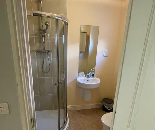 uma casa de banho com um chuveiro e um lavatório. em Holiday Home In Cardiff, Sleeps 8 em Cardiff
