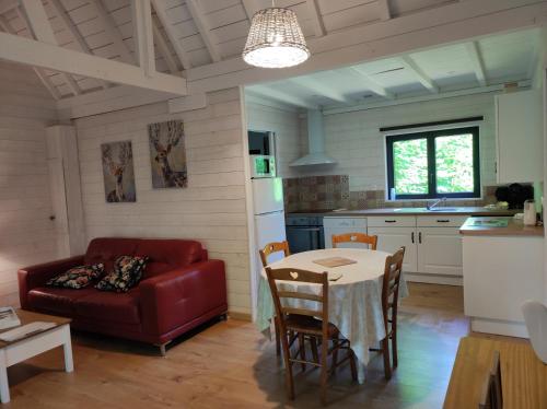 sala de estar con sofá rojo y mesa en Gîte avec SPA privé près zoo Beauval et châteaux, en Oisly