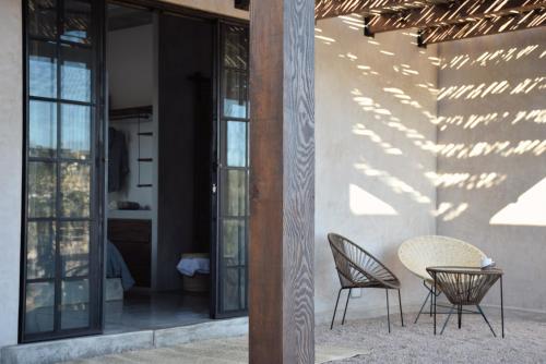 a patio with two chairs and a table at Desierto Azul in Todos Santos