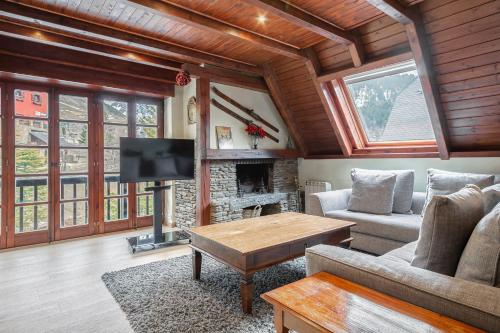 a living room with a couch and a fireplace at Luderna - Tríplex Nin C2 Arenho in Naut Aran