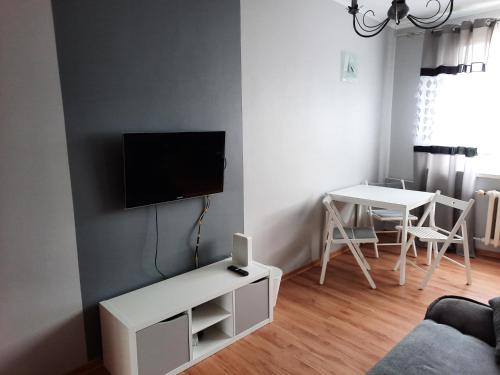 a living room with a tv and a table at Jelitkowo Beach Apartment in Gdańsk