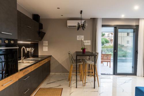 a kitchen with a counter and a table with chairs at Muse by the beach with Jakuzzi in Amoudara Lasithiou