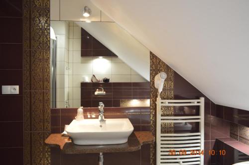 a bathroom with a sink and a mirror at Zajazd Złota Podkowa in Wrocki